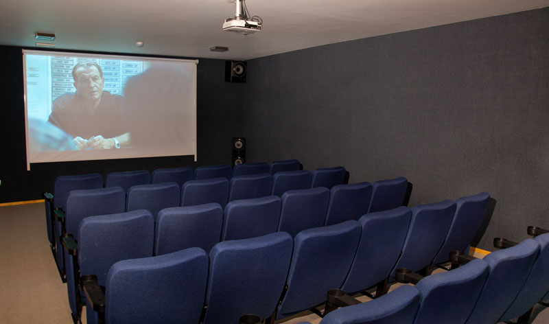 Sala de cine con butacas azules y pantalla