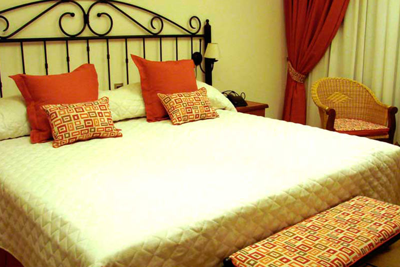 Habitación estándar doble con cama matrimonial y cortinas rojas